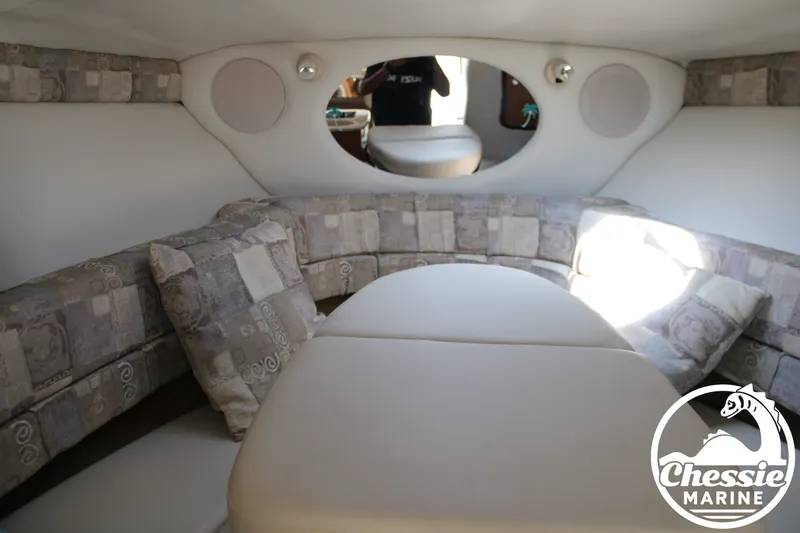 Slide: The Image of Interior of a 2006 Crownline 250 with cushioned seating and an oval mirror. - 48