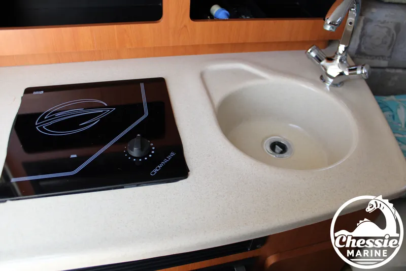 Slide: The Image of Galley with sink and stove in a 2006 Crownline 250 boat. - 36