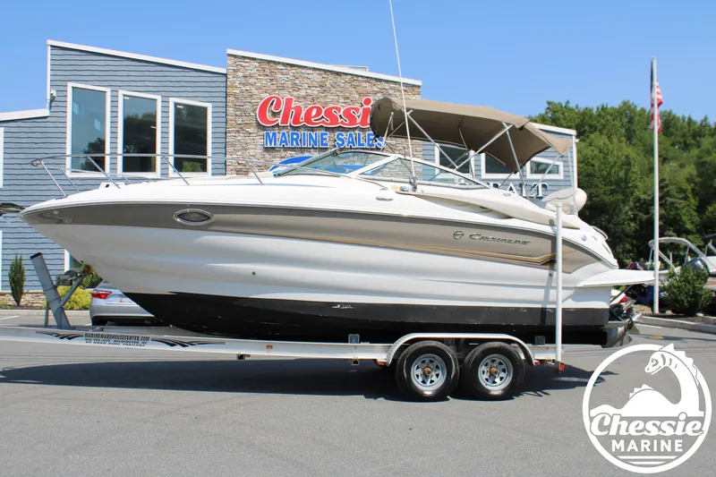 The Image of A 2006 Crownline 250 on a trailer in front of a building with a "Chessie Marine Sales" sign. - 1