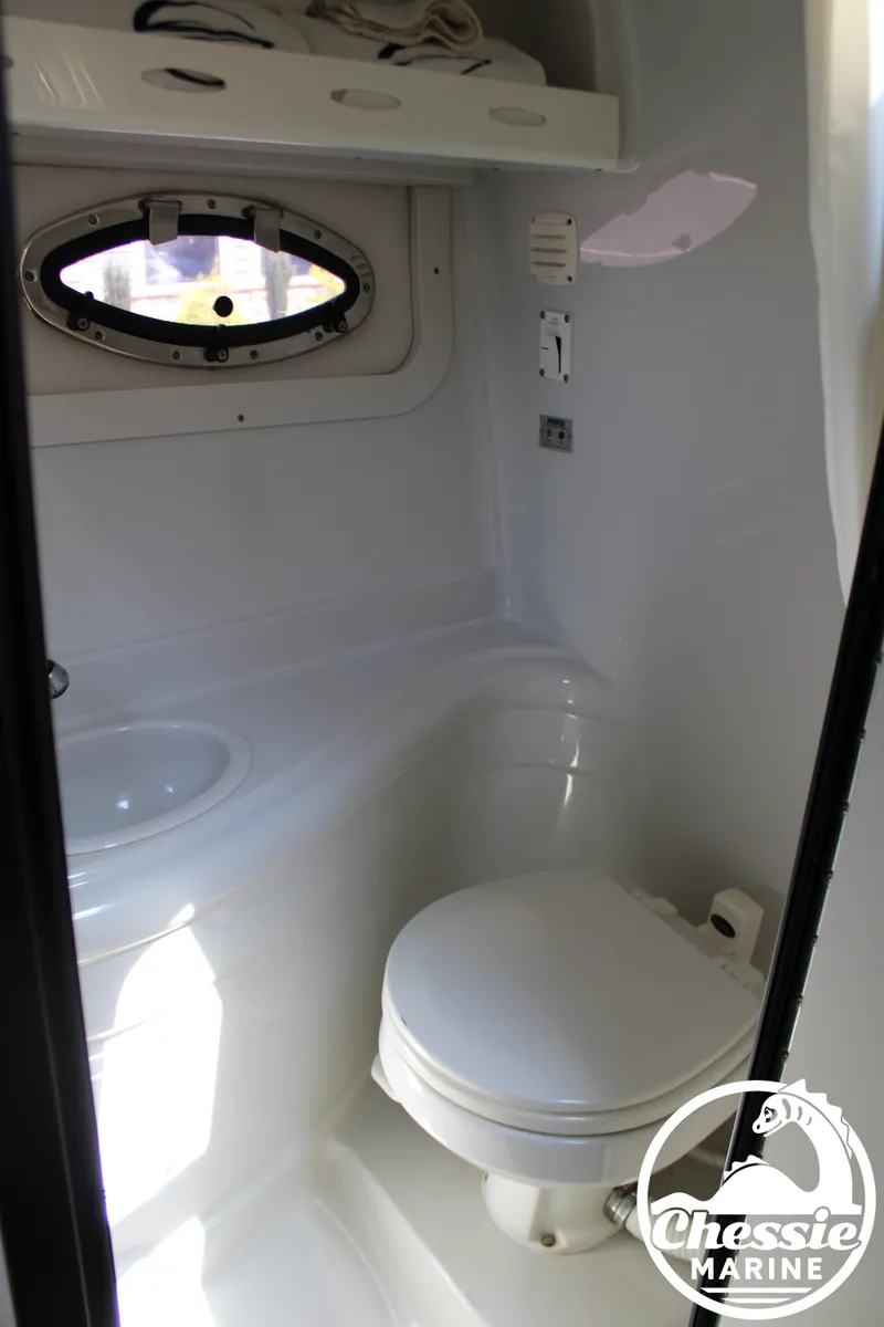 Slide: The Image of The image shows a clean, white bathroom with a porthole and a toilet. - 46