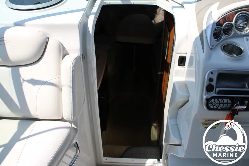 Slide: The Image of The cabin of a 2006 Crownline 250 with white seating and a helm area. - 32