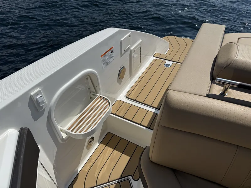 Slide: The Image of The image shows the stern of a Sea Ray SLX 310 with sleek wood flooring and comfortable seating. - 12