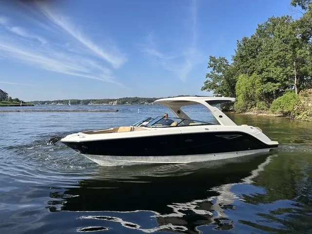 Slide: The Image of 2027 Sea Ray SLX 310 on calm water, surrounded by trees. - 3