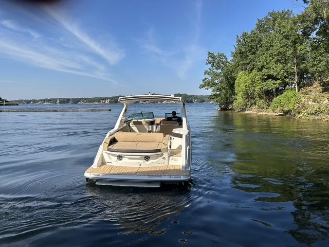 Slide: The Image of A 2027 Sea Ray SLX 310 on calm waters, surrounded by trees. - 5
