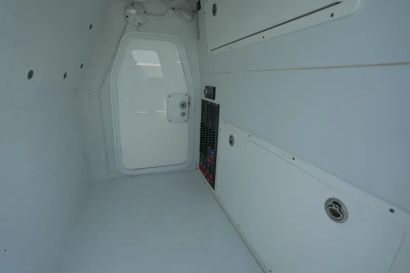 Slide: The Image of Interior cabin of 2024 Freeman 42 boat, featuring white panels and a closed door. - 29