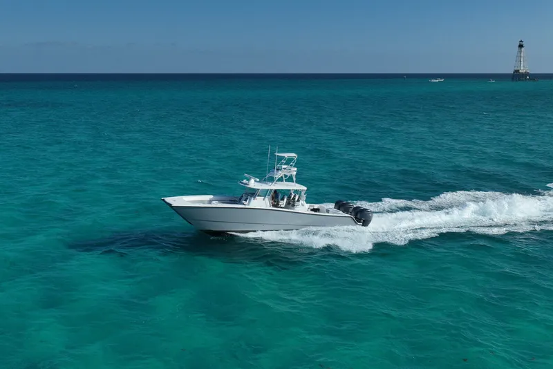 Slide: The Image of 2024 Freeman 42 boat cruising on turquoise ocean near a lighthouse. - 18