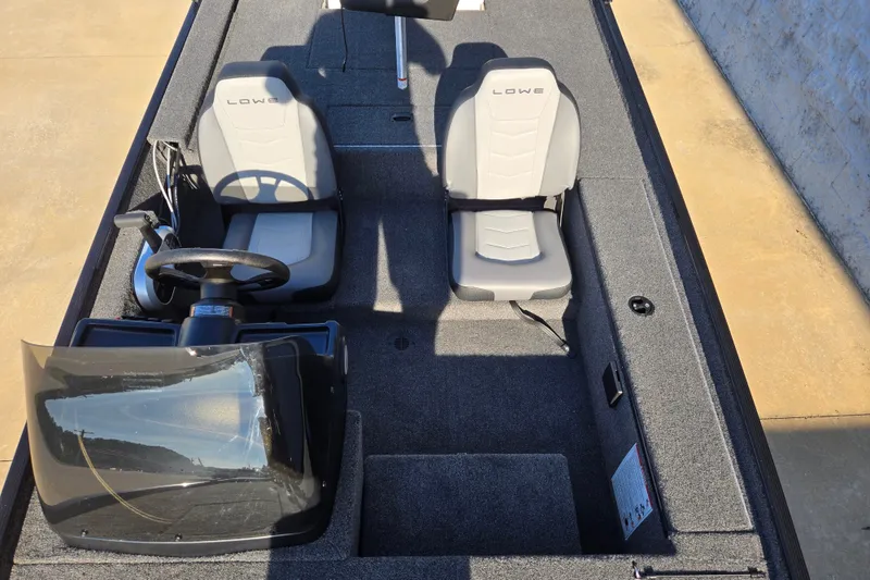 Slide: The Image of 2027 Lowe Skorpion 16 boat interior with two seats and steering console. - 9