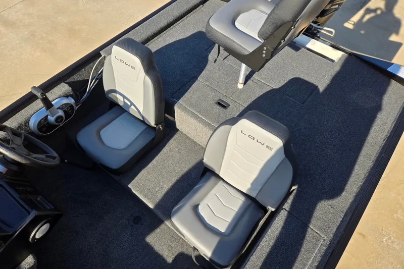 Slide: The Image of 2027 Lowe Skorpion 16 boat interior with gray seating and steering console. - 10