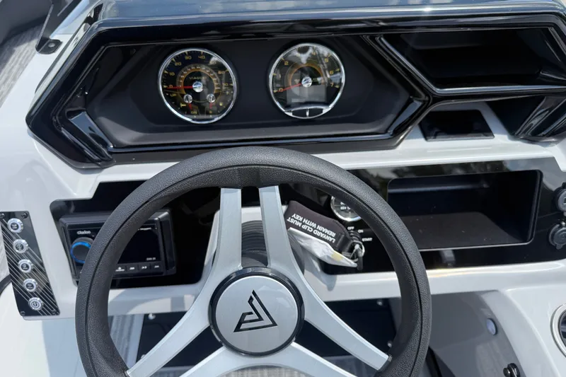 Slide: The Image of Steering wheel and dashboard of 2027 Viaggio x22u boat, featuring modern gauges and controls. - 22