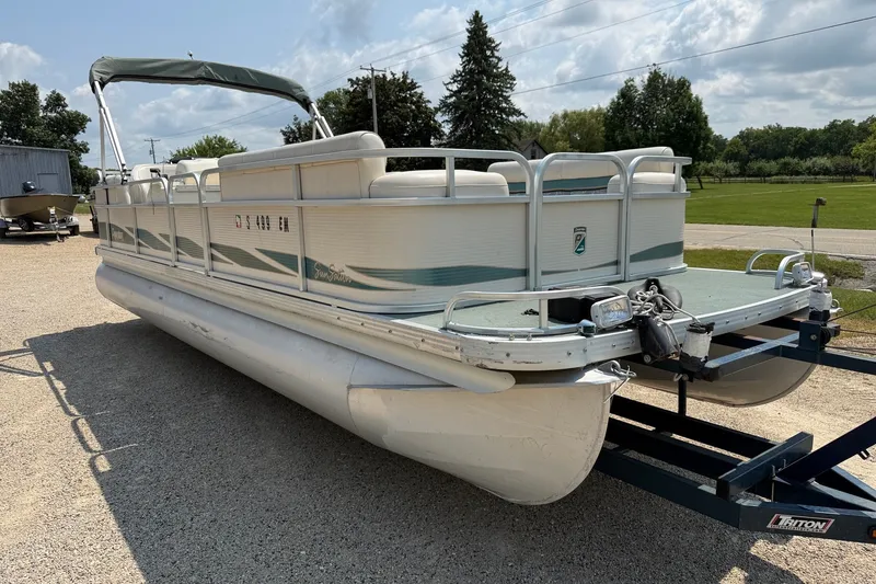 Slide: The Image of 1998 Premier SunSation 250 pontoon boat on trailer, parked outdoors. - 16