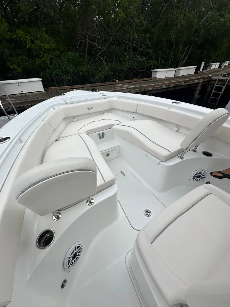 Slide: The Image of The image shows the cockpit of a 2025 Sea Hunt Ultra 255SE boat with white upholstery. - 7