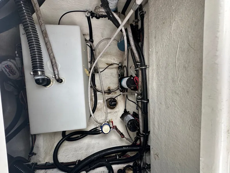 Slide: The Image of View inside the engine compartment of a Sea Hunt Ultra 255SE boat with hoses and wires. - 9