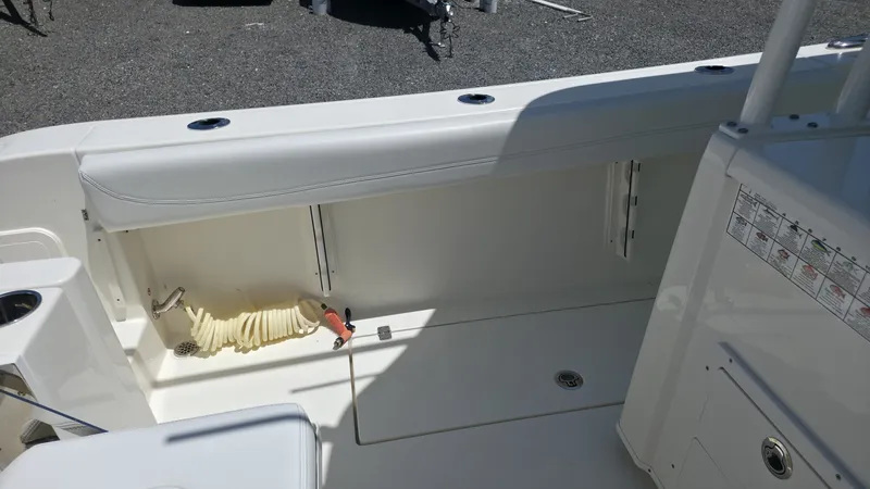 Slide: The Image of The image shows the cockpit of a Cobia 301 Center Console boat with storage and a hose. - 10