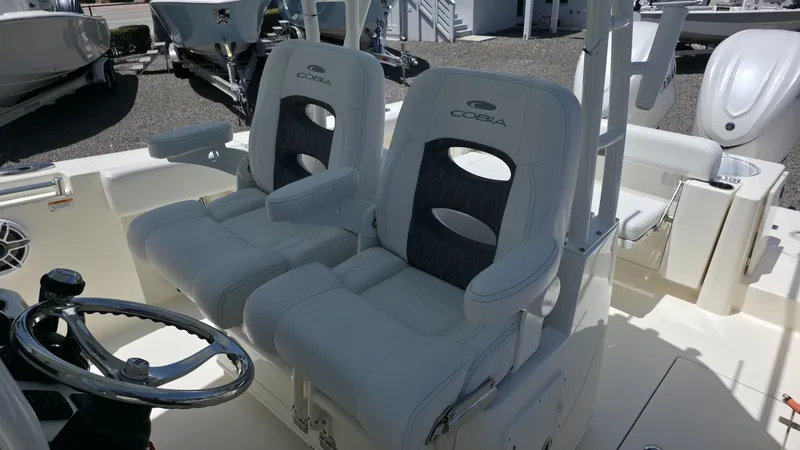 Slide: The Image of Two luxurious, cushioned seats on a Cobia 301 Center Console boat, featuring a sleek steering wheel. - 8