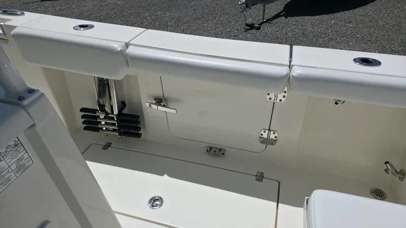 Slide: The Image of The image shows the cockpit of a 2025 Cobia 301 Center Console boat with storage and rod holders. - 11
