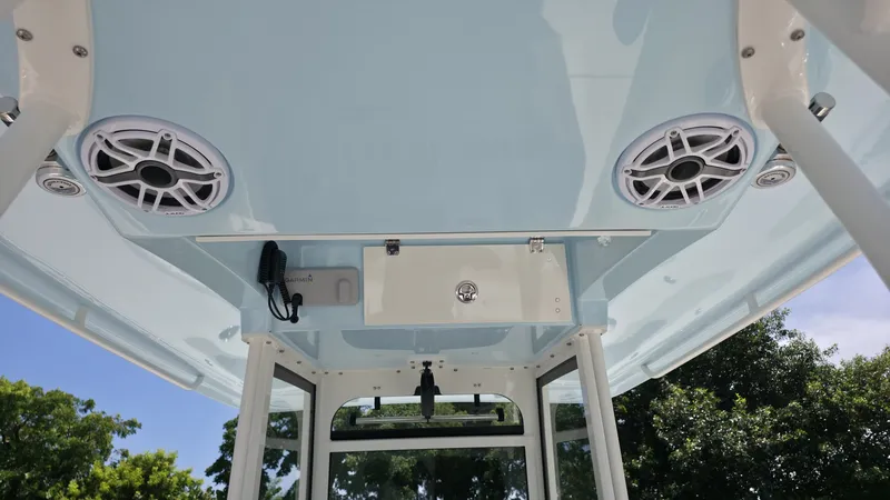 Slide: The Image of The image shows the roof of a Cobia 301 Center Console boat with speakers and a radio. - 13