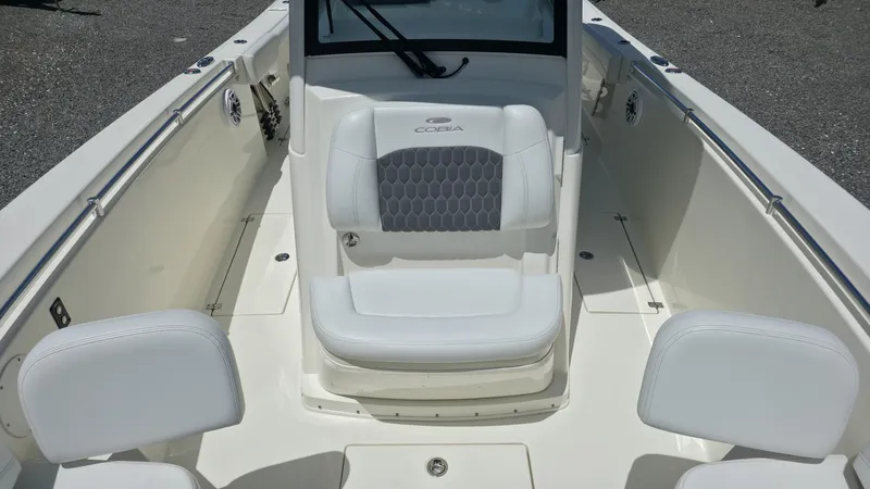 Slide: The Image of The image shows the cockpit of a 2025 Cobia 301 Center Console boat with white seating. - 16