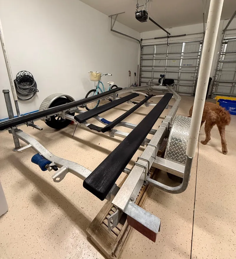 Slide: The Image of A boat trailer is parked in a garage next to a bicycle and a dog. - 20
