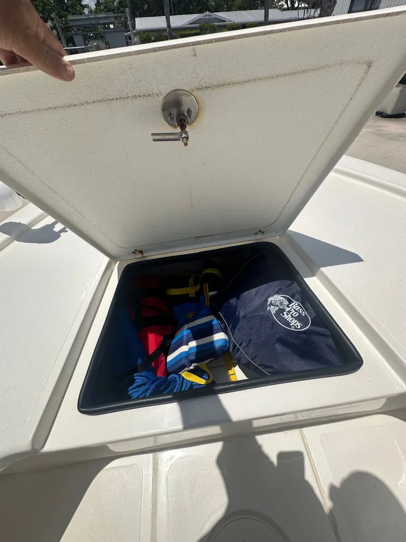 Slide: The Image of An open storage compartment on a Mako 18 LTS boat, filled with ropes and a bag. - 18