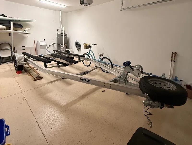 Slide: The Image of A boat trailer is parked in a garage next to a bicycle and shelves. - 19
