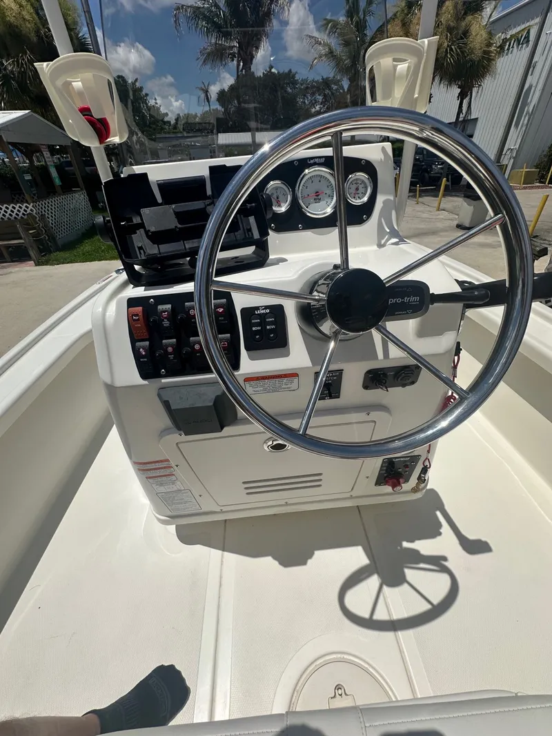 Slide: The Image of The image shows the helm of a 2024 Mako 18 LTS boat with a steering wheel and instruments. - 14