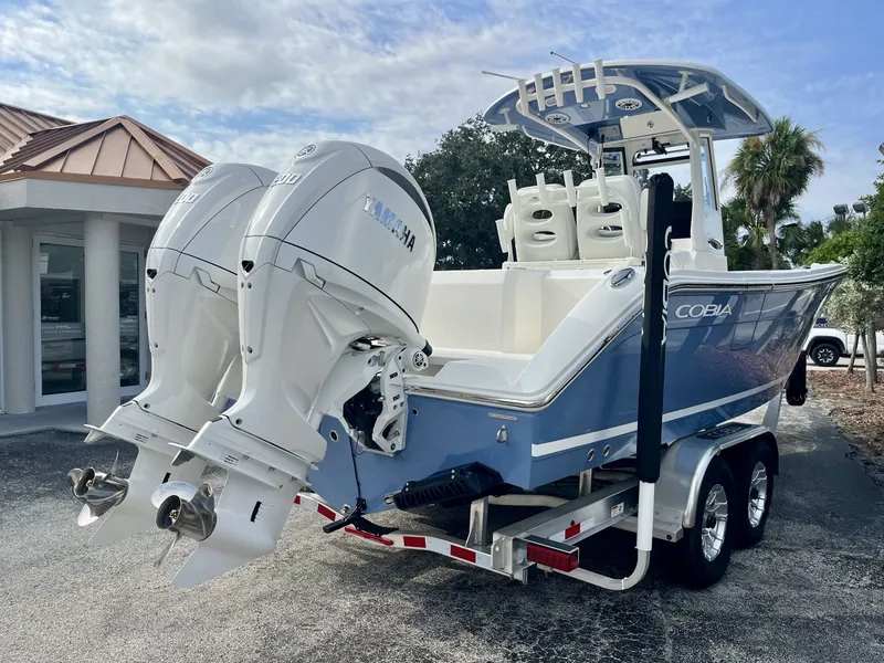 Slide: The Image of 2027 Cobia 265 Center Console with twin outboard engines on a trailer. - 6