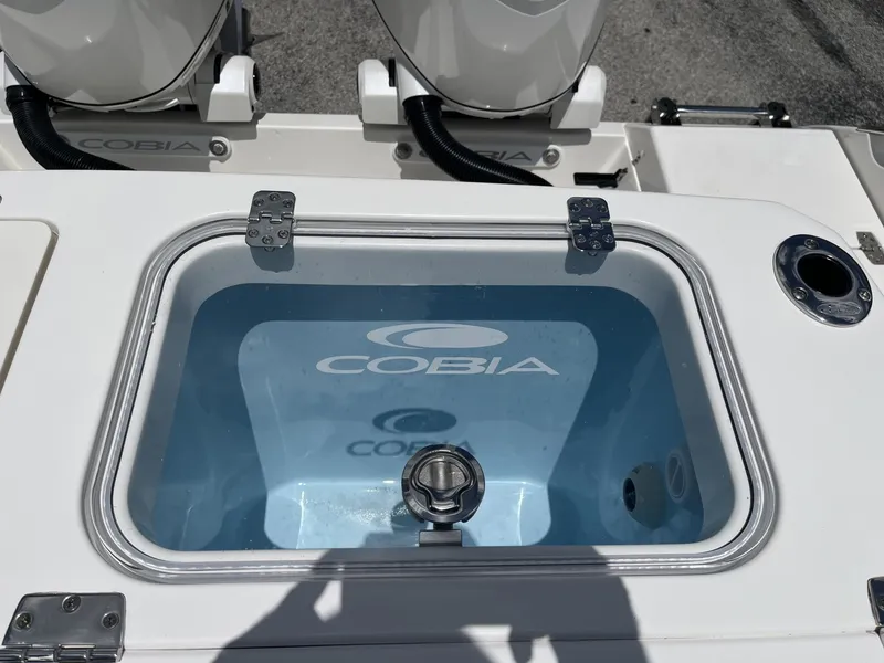 Slide: The Image of A Cobia 265 Center Console boat with a blue livewell featuring the Cobia logo. - 36