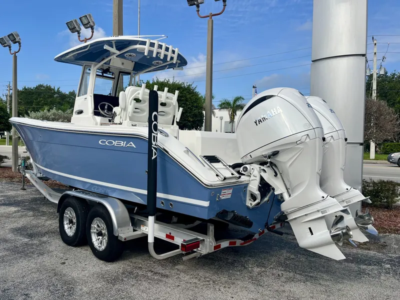 Slide: The Image of A 2027 Cobia 265 Center Console boat on a trailer with twin Yamaha outboard engines. - 4