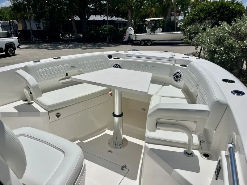Slide: The Image of The 2027 Cobia 265 Center Console features a spacious seating area with a table and cushioned seats. - 29