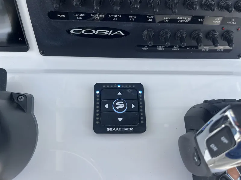 Slide: The Image of The image shows the helm of a Cobia 265 Center Console boat with a Seakeeper control panel. - 21