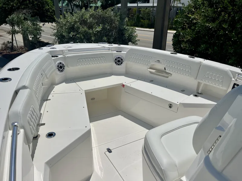Slide: The Image of The image shows the spacious bow area of a Cobia 265 Center Console boat with white upholstery. - 22