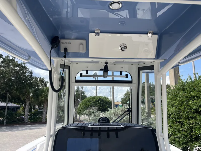 Slide: The Image of The image shows the cockpit of a 2027 Cobia 265 Center Console boat with a blue canopy. - 17