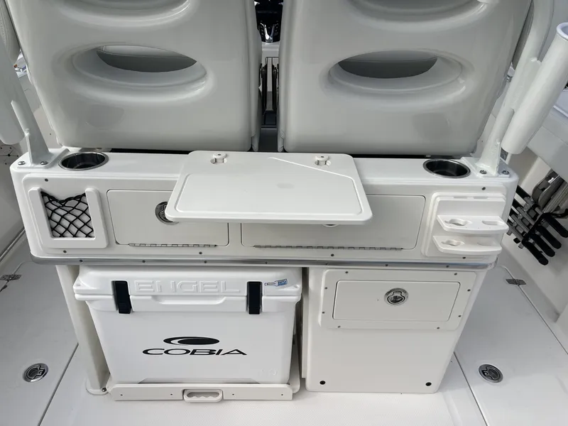 Slide: The Image of The image shows the cockpit of a Cobia 265 Center Console with storage and a cooler. - 13