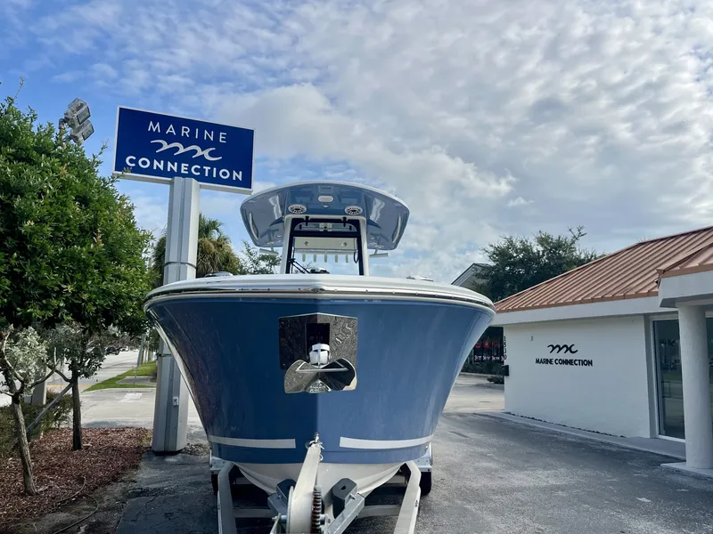 Slide: The Image of A 2027 Cobia 265 Center Console boat on a trailer in front of a building. - 3