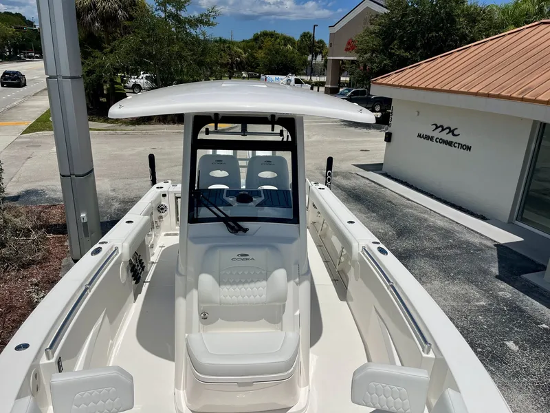 Slide: The Image of The image shows a 2027 Cobia 265 Center Console boat parked at a marina. - 27