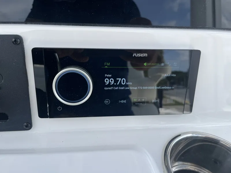 Slide: The Image of A Fusion marine radio displays 99.70 MHz FM, installed in a boat. - 18