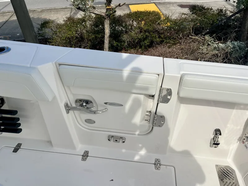 Slide: The Image of The image shows the deck of a Cobia 265 Center Console boat with white upholstery and metal fittings. - 14