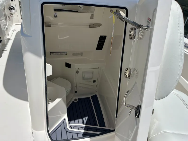 Slide: The Image of The image shows the interior of a modern boat's restroom with white walls and blue floor mats. - 30