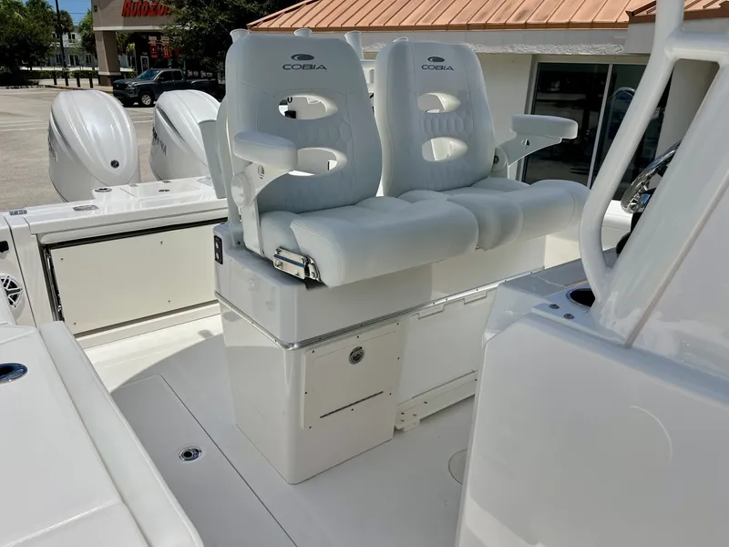 Slide: The Image of The image shows the seating of a 2027 Cobia 265 Center Console boat, featuring white upholstery. - 32