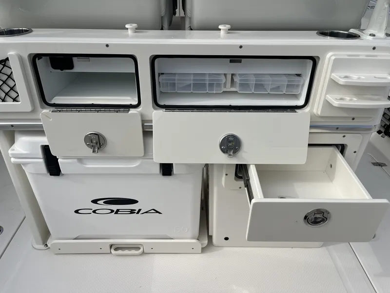 Slide: The Image of The image shows the storage compartments and drawers of a Cobia 265 Center Console boat. - 12