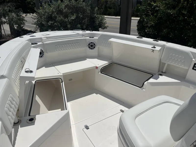 Slide: The Image of The image shows the cockpit of a 2027 Cobia 265 Center Console boat with white upholstery. - 23