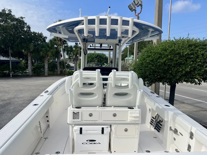Slide: The Image of The image shows a 2027 Cobia 265 Center Console boat. It features a spacious deck with two seats and a blue canopy. - 11