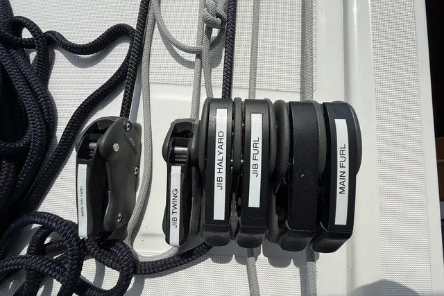 Slide: The Image of Sailing controls on Jeanneau Sun Odyssey 410, 2022 model, featuring labeled rope clutches. - 23