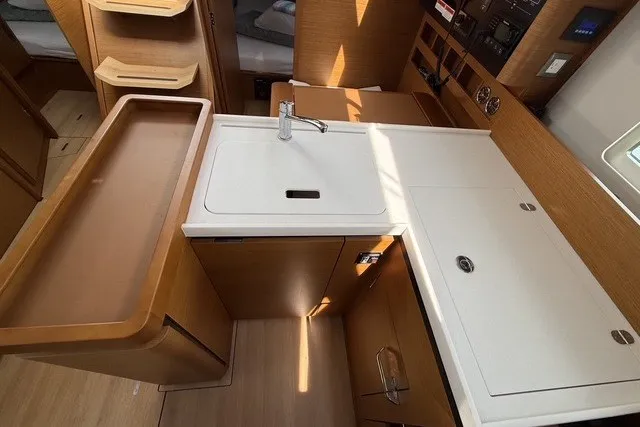 Slide: The Image of Modern kitchen area in 2022 Jeanneau Sun Odyssey 410 yacht, featuring sleek cabinetry and sink. - 40