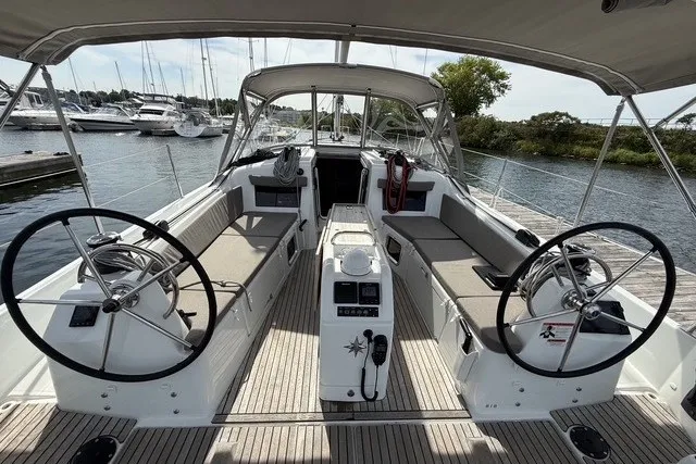 Slide: The Image of 2022 Jeanneau Sun Odyssey 410 sailboat cockpit with dual steering wheels, docked at marina. - 6