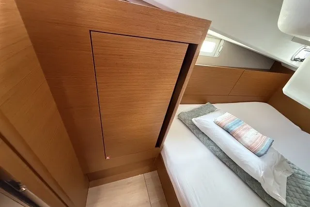 Slide: The Image of Interior cabin of 2022 Jeanneau Sun Odyssey 410 yacht with wooden paneling and cozy bedding. - 54