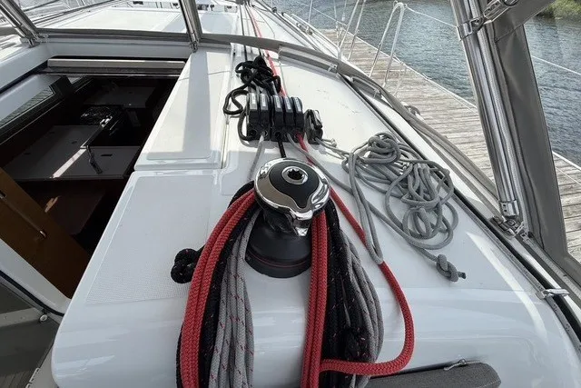 Slide: The Image of 2022 Jeanneau Sun Odyssey 410 sailboat deck with ropes and winch, docked by the water. - 20