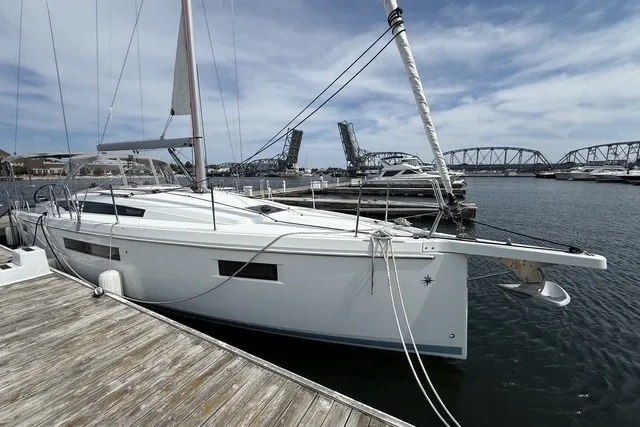 Slide: The Image of 2022 Jeanneau Sun Odyssey 410 sailboat docked near a bridge on a sunny day. - 3