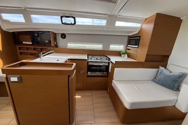 Slide: The Image of Interior of 2022 Jeanneau Sun Odyssey 410 yacht, featuring modern kitchen and seating area. - 39