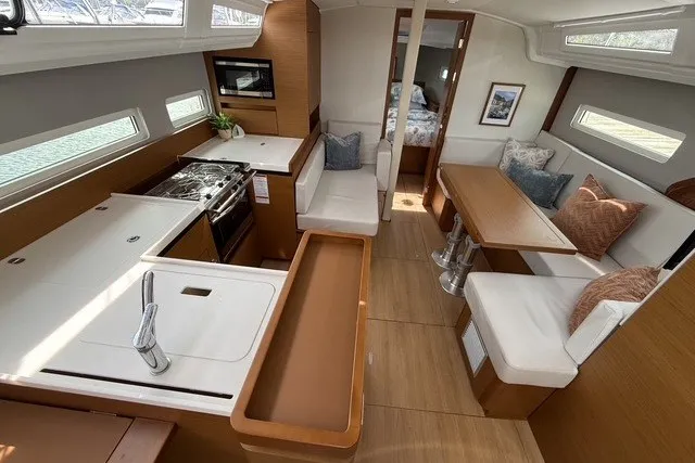 Slide: The Image of Interior of 2022 Jeanneau Sun Odyssey 410 yacht, featuring modern kitchen and cozy seating area. - 32